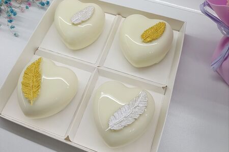 Белые муссовые пирожные ассорти с шоколадными перышками на день Влюблённых