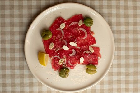 Карпаччо из тунца с оливками и маринованным миндалем