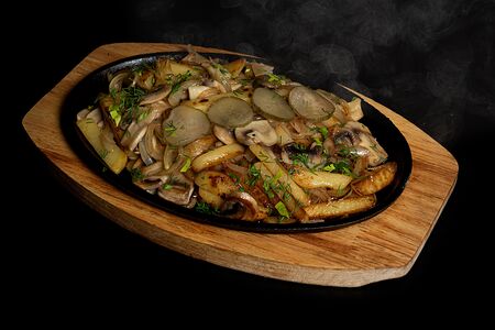 Горячая сковорода с жареной картошкой и луком