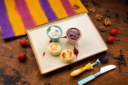 Сырники со сметаной и малиновым джемом