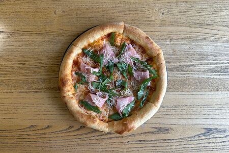 Пицца с ветчиной из телятины, томатным соусом, рукколой и пармезаном