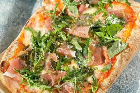 Фирменная пицца Gastrobar с прошутто, рукколой, моцареллой, пармезаном и соусом Песто