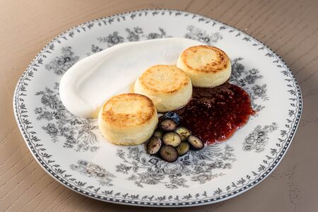 Сырники с черничным вареньем и сметаной