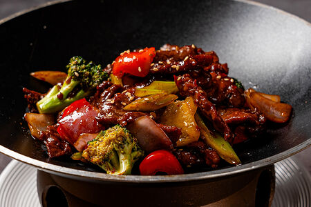 Кусочки говядины с овощами, обжаренные на воке