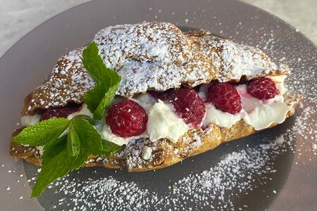 Круассан со взбитыми сливками и малиной