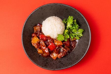 Свинина в кисло-сладком соусе, жаренная с овощами и ананасом