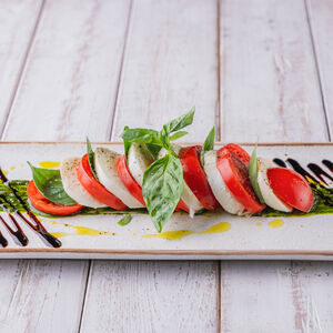 Моцарелла с помидорами и соусом из базилика