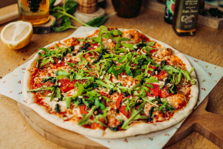 Пицца с моцареллой, помидорами, листьями рукколы