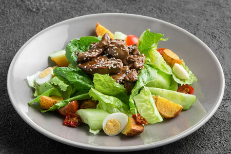 Салат с карамельной куриной печенью, печеным картофелем и вялеными томатами	
