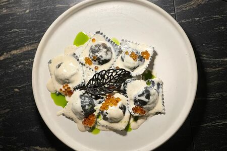 Черные равиоли с морепродуктами и соусом сливочный биск