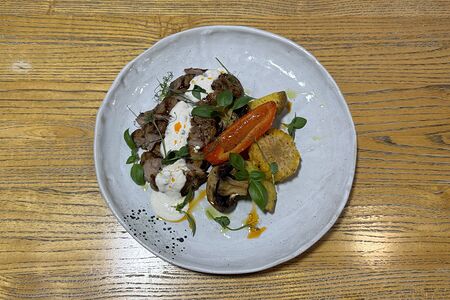 Стейк из свиной шеи с печеными овощами и перечным соусом 