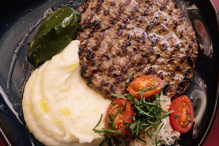 Плескавица с картофельным пюре и кремом из трав