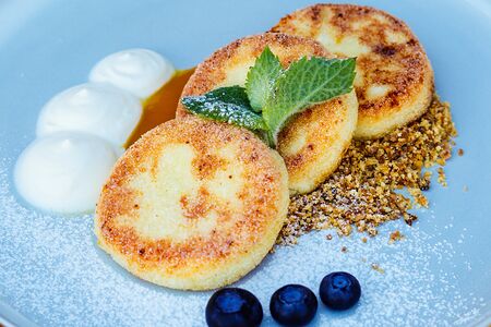 Сырники с пюре манго, сметаной и карамелизированным белым шоколадом