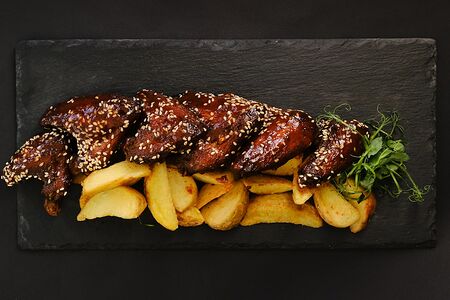 Куриные крылышки в соусе BBQ с картофелем по-деревенски