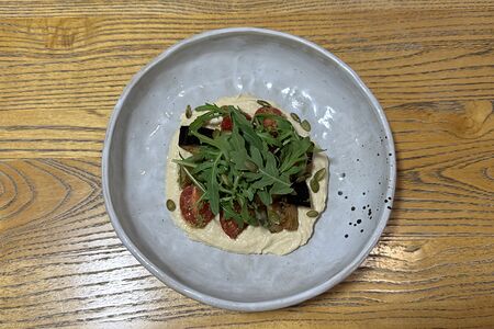 Салат с хумусом, хрустящим баклажаном, томатами и сыром страчателла