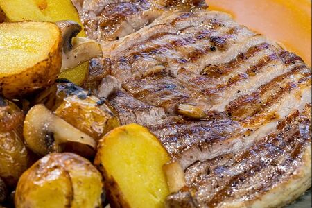 Стейк из свинины с печеным картофелем, грибами и сырно-мясным соусом 