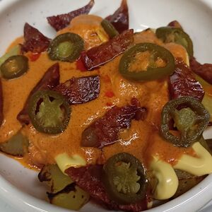 Пататас бравас с чоризо, халапеньо и сырным соусом