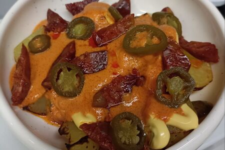 Пататас бравас с чоризо, халапеньо и сырным соусом