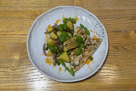 Запеченное филе сибаса с ароматным картофелем, зеленым горошком и красным луком