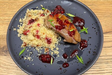 Утиная грудка с кускусом и брусничным соусом