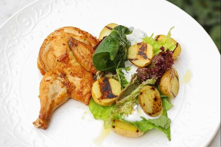 Половинка цыпленка с печеным картофелем и йогуртовой заправкой