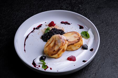 Сырники с кремом из маскарпоне и черничным соусом 