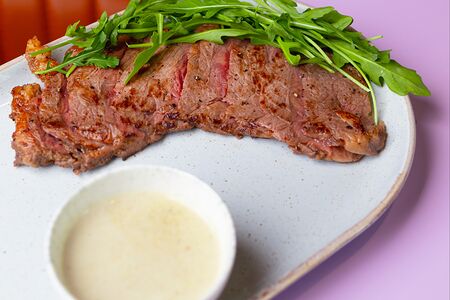 Стейк стриплойн со сливочно-перечным соусом и рукколой
