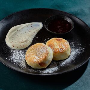 Сырники с изюмом, сметаной и брусничным соусом