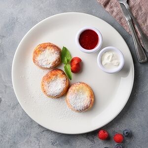 Фирменные сырники с протертой малиной и сметаной