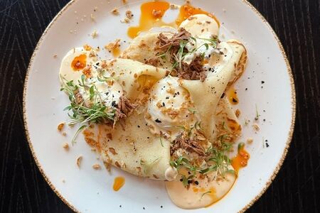 Блины с томленой говядиной, яйцо пашот и сырным соусом