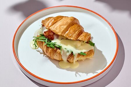 Круассан с омлетом и беконом под соусом Цезарь