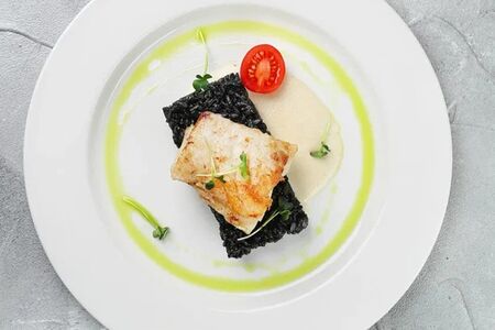 Угольная рыба с черным ризотто и соусом из белого вина