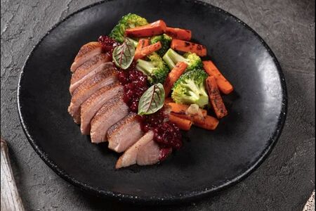 Томленая утка с овощами и соусом из ягод брусники