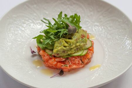 Тартар из лосося с гуакамоле, огурцом и рукколой 