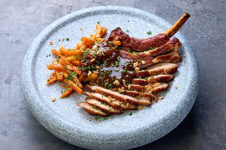 Томагавк из поросенка с пряной морковью на углях