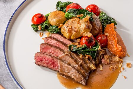 Фланк-стейк с картофелем, шпинатом, томатами черри