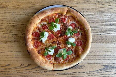 Пицца с томатами, сыром страчателла, песто и красным маслом