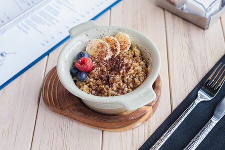 Цельнозерновая овсяная каша с ягодами, бананом, орехом и шоколадом