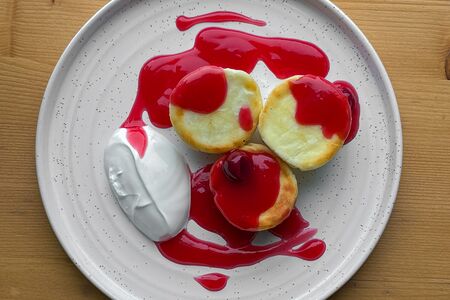 Сырники с соусом из вишни и сметаной