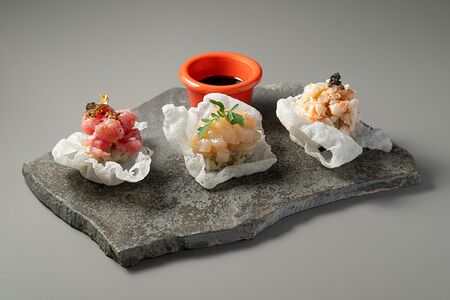 Тартар из тунца, креветки и гребешка на рисовой подушке