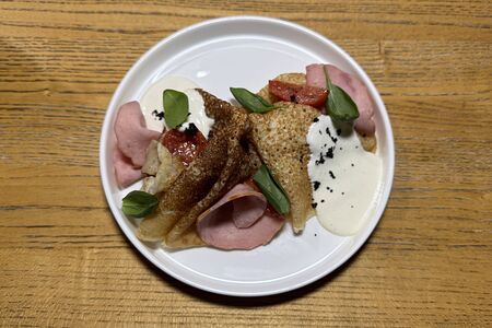 Блины с ветчиной из телятины, томатами черри, молодым шпинатом и сливочным соусом