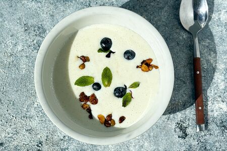 Взбитая манная каша с карамелизированными орехами, сухофруктами и вареньем из черной смородины