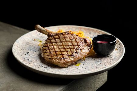 Свиная корейка на кости, тушеная капуста, брусничный соус