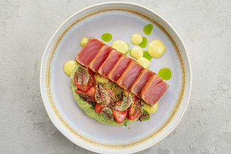 Стейк из тунца с мятым авокадо и спелыми томатами