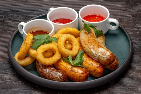 Дублинские колбасы на гриле с луковыми кольцами и тремя соусами
