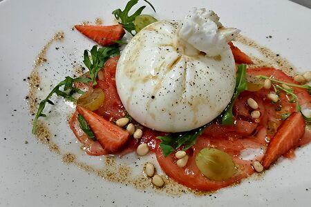 Буррата с карпаччо из помидоров, клубникой и кедровыми орешками
