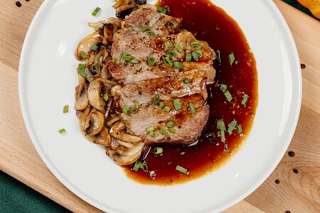 Фермерский стейк из свиной шеи с жареными грибами и луком