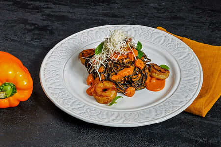 Черные спагетти с креветками и соусом биск