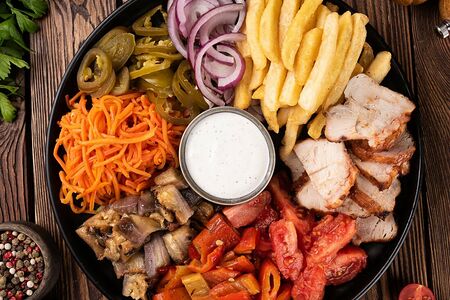 Шаверма на тарелке с овощами на мангале