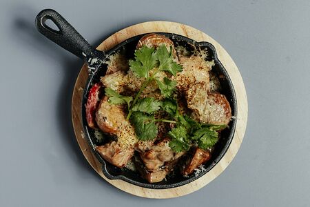 Горячая сковородка с цыпленком и овощами в сливочном соусе под сырной коркой